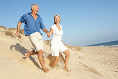 Senior Couple Enjoying Beach Holiday Running D...
