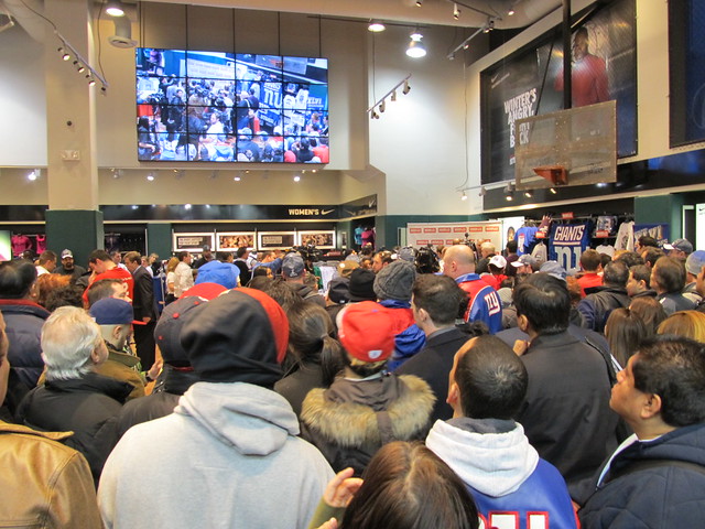 Crowds in Modells Times Square watch as Giants players MARIO MANNINGHAM and Dave Tollefson participate in photo ops, 02/06/12 (IMG_6319)