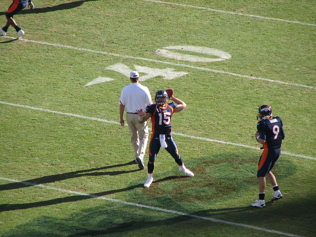 Tim Tebow Warming Up Before The Game Beside BRADY QUINN