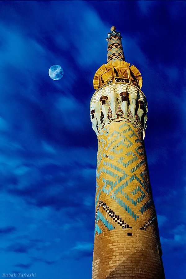 Полная Луна светит в вечернем небе над старинным минаретом текие (ритуального сооружения) Амир-Чагмах в Йезде (центральный Иран).