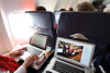 Digital reporting quickly begins as University Communications staff work on their laptop computers amid Wisconsin fans traveling on a Rose Bowl charter flight bound for Los Angeles. (Photo by Jeff Miller)