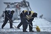 Flight Deck Crews Clear Snow and Ice Onboard HMS Illustrious Near Norway