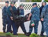 Navy personal carry away the ejection seat from the Navy F/A-18 Hornet that slammed into an apartment complex in Virginia Beach, Virginia April 6, 2012. A U.S. Navy F/A-18D fighter crashed soon after take-off into an apartment complex in Virginia on Frida