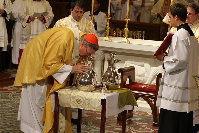 Cardinal breathes over blessed Holy Oils