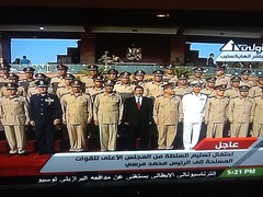 Mohamed Morsi standing with army commanders