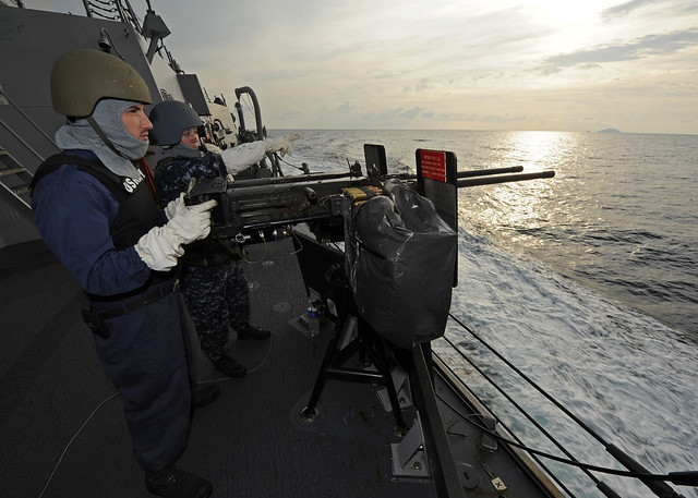 A Sailor mans a mounted machine gun.
