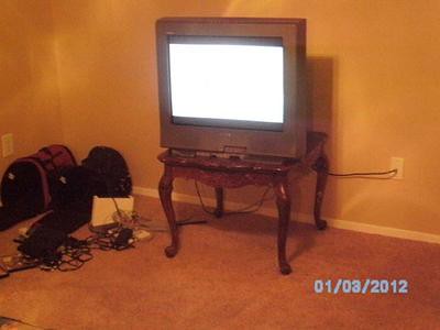 A TV that I bought, sitting on a table that my big sister bought