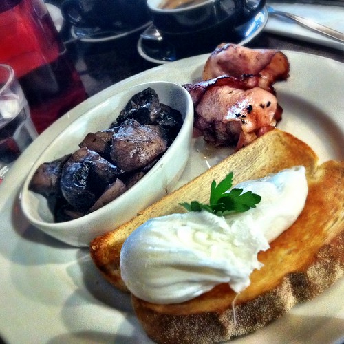 Poached eggs on toast with sides of bacon and truffled mushroom