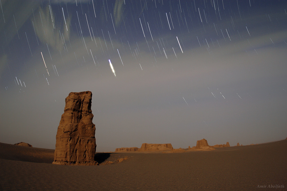 Звёзды и облака апрельской лунной ночью движутся на западным горизонтом пустыни Лут в провинции Керман. 