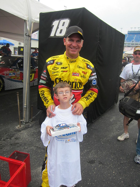 Clint Bowyer poses with a NASCAR Dreams child at the track
