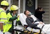 A man is taken away by paramedics at the scene of accident after a U.S. Navy F/A-18D fighter jet crashed into an apartment complex in Virginia Beach April 6, 2012. The Navy fighter crashed soon after take-off into an apartment complex in Virginia on Frida