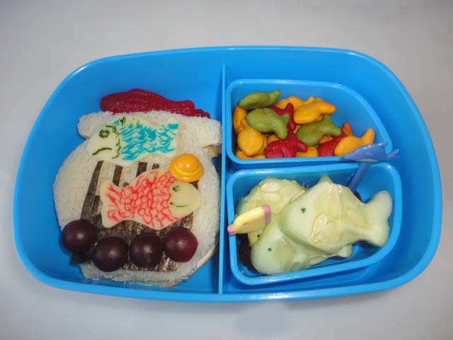 Dr.Seuss Bento: One Fish, Two Fish, Red Fish, Blue Fish in a sandwich bowl,grapes,fish shaped cucumbers,cheddar goldfish,gummy fish 3-1