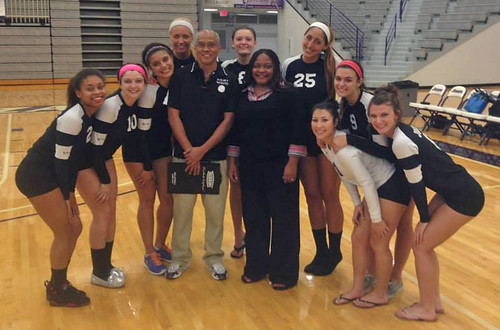 Kisha Cameron, women's volleyball coach at Joliet Junior College, is pictured in the center, surrounded by the JJC volleyball team and Jesse Aquino, assistant volleyball coach.