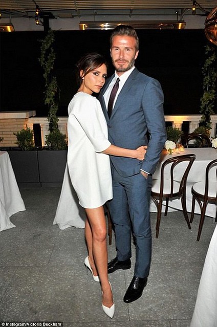 Victoria Beckham cuddles up to dapper husband David at fashion dinner