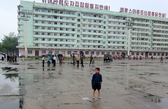 North Korea Hamhung drab apartment building and lost-looking kid who drew a paparazzi crowd