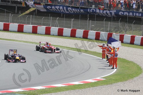 Fernando Alonso celebrates winning the 2013 Spanish Grand Prix, waving the Spanish flag