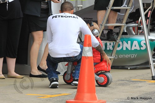 Lewis Hamilton gives a child a tour of his pit garage at the 2013 Spanish Grand Prix