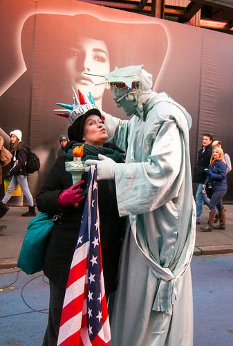 nyc newyorkcity woman ny newyork kiss manhattan flag americanflag shades billboard christmaslights midtown torch timessquare pedestrians crown statueofliberty holidaylights vornado