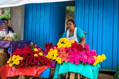 A woman setting out flowers in front of her store.